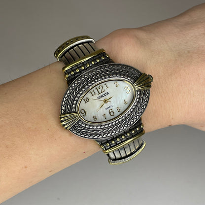 Reloj Joya Chico’s ovalado bicolor / brazalete ornamental Año 2005 Estética Bohemia y Western